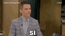 a man in a suit and a plaid shirt says si on a television show