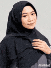 a woman wearing a black hijab with shotcut ai video editor on the bottom