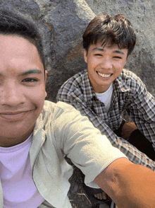 two young men are posing for a picture and one of them is smiling