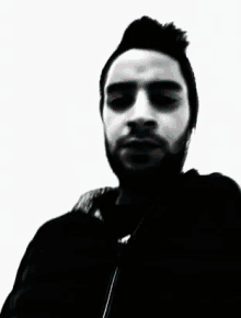 a man with a beard is wearing a black shirt