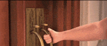 a close up of a person 's hand holding a door handle .