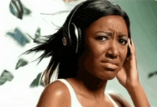 a woman wearing headphones is crying while listening to music .
