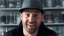 a man wearing a nike hat is smiling in front of a shelf full of shoes