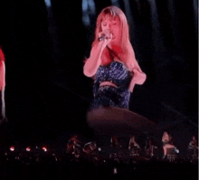 taylor swift is dancing on a stage in front of a crowd .