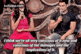 a man and a woman are sitting next to each other with a microphone in their hands .