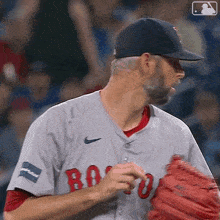 a man wearing a boston red sox jersey and a nike hat