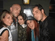 a group of people posing for a picture with one wearing a shirt that says infinite on it