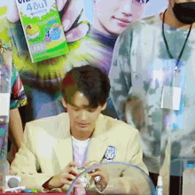 a man in a suit is sitting at a table holding a box of juice