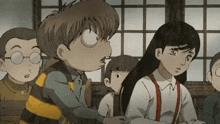 a group of children are sitting in a classroom and one of them is wearing suspenders