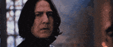 a close up of a man with long hair making a funny face in front of a window .