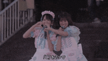 a couple of girls standing next to each other with the letters ic visible