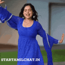 a woman in a blue dress is dancing in front of a sign that says startamlchat.in