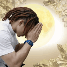 a man with dreadlocks has his hands folded in prayer