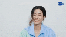 a close up of a woman wearing a blue shirt and smiling .