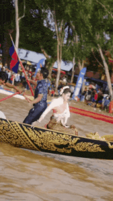 a man and a woman in a boat in the water with a flag in the background