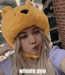 a woman wearing a winnie poo hat takes a picture