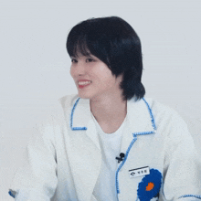 a woman wearing a white jacket with a name tag that says ' a ' on it