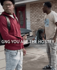 two men standing in front of a brick house with the words gng you are the hoster