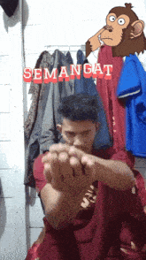 a man with a monkey behind him that says " semangat " on it