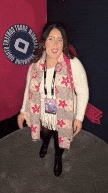 a woman wearing a scarf stands in front of a sign that says " studio dewey "