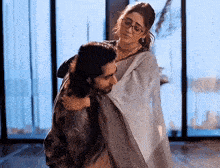 a man is carrying a woman in his arms in a room .