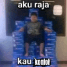 a boy is sitting on top of a stack of boxes .