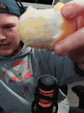 a man wearing a paw patrol shirt holds a piece of food in his hand