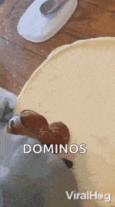 a person is putting dominoes on top of a piece of dough .