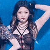 a woman is standing on a stage with a microphone in her mouth and holding her hair .