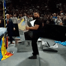 a man in a black shirt is holding a sign that says time on the floor