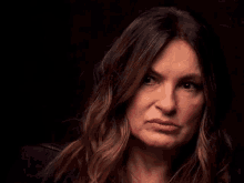 a woman with long hair is making a serious face