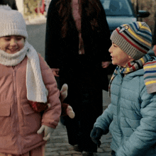 a boy wearing a hat with a penguin on it is walking with a girl