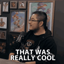 a man sitting in front of a microphone with the words that was really cool above him