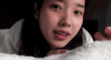 a close up of a woman 's face with a white towel in front of her .