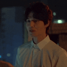 a man in a white shirt is smiling and looking at something