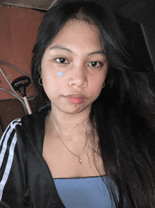 a young woman with a blue star on her cheek