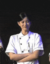 two women in chef 's uniforms are standing next to each other on a stage .