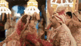 a bride and groom are dancing together at a wedding reception in a crowd of people .
