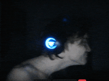 a person wearing a pair of headphones with a blue light on the ear