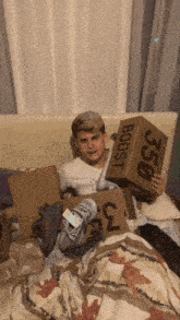 a man laying on a bed holding a box that says boost 350