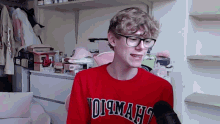 a young man wearing glasses and a red shirt that says oi maht