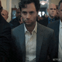 a man in a suit stands in a crowd with a netflix logo on the bottom
