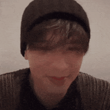 a close up of a person wearing a beanie and sweater