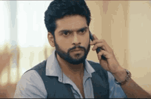 a man with a beard is talking on a cellphone