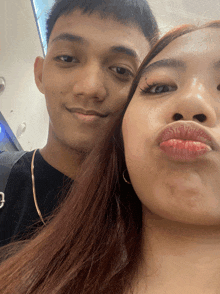 a man and a woman are posing for a picture and the woman has red lipstick on