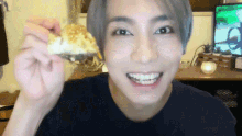 a young man is holding a piece of food in his hand