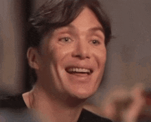a close up of a man 's face smiling with his mouth open