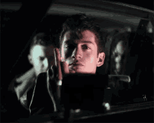 a man is smoking a cigarette while sitting in a car .
