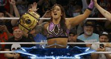 a woman in a wrestling ring holds up a championship trophy