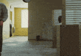 a man stands in a hallway with a clock above him